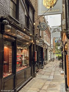 an alley way with shops and signs on the side of each building in front of it