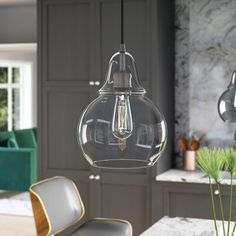 a glass light fixture hanging over a kitchen table with two chairs in front of it