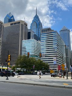 a city street with tall buildings and traffic lights in the foreground, on a cloudy day