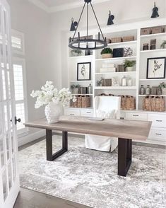 a large wooden table sitting on top of a rug in front of a book shelf