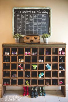 a chalkboard on the wall above a shoe rack