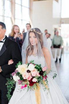 a bride and groom walking down the aisle