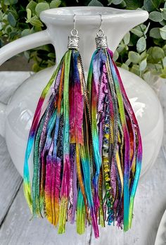 These vibrant tassel earrings will add the perfect pop of color to your wardrobe whether you're wearing a simple t-shirt and jeans or heading out in your favorite dress!  These fun earrings are made from carefully selected, high quality pieces of beautiful, rare novelty yarns.  The tassel part of the earring measures approximately 6 inches with a total drop length of 7 inches when including the earring end cap.  The end cap has a pretty antique heart pattern and the earring wire is stainless ste Bohemian Tassel Earrings With Fringe For Spring, Trendy Fringe Drop Earrings, Colorful Bohemian Jewelry For Summer, Colorful Bohemian Summer Jewelry, Multicolor Tassel Earrings For Festival, Adjustable Funky Earrings For Festivals, Trendy Green Tassel Dangle Earrings, Trendy Green Tassel Drop Earrings, Trendy Green Dangle Tassel Earrings