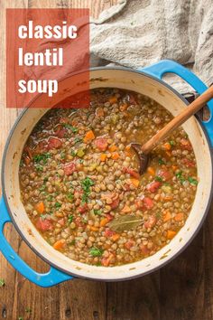 a blue pot filled with beans and carrots on top of a wooden table next to a