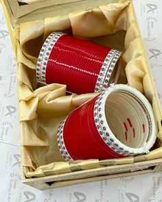 two red cups sitting in a box on top of a table