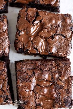 brownies with chocolate frosting sitting on a white surface