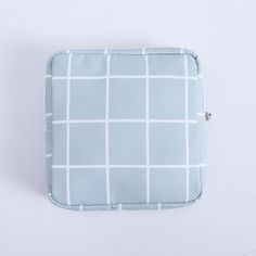 a blue and white checkered pillow on a white surface with a zippered closure