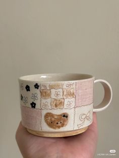 a hand holding a coffee cup with teddy bears on it