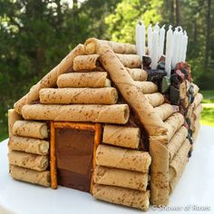 a cake made to look like a log house with candles on the outside and inside