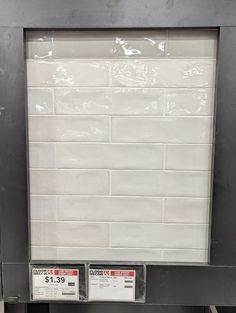 a white brick wall with two price tags on it