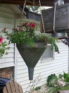 a hanging planter filled with flowers in front of a house