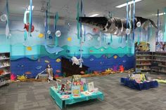 an ocean themed library with bookshelves, tables and balloons hanging from the ceiling