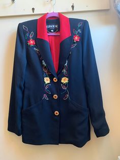 Wow how stunning is this vintage blazer?! Black with red colour way and both stitched and appliqué flowers details. Also let's not overlook the gold tone jewelled buttons. Not for the faint of heart definitely for someone who loves fashion and has been looking for that statement piece. It does have a padded shoulder typical of the 80's.  In very good preowned condition however as with all vintage items some wear is expected. Size XS Shoulders approx 16" Length 27" Waist approx 15-5" V3 Vintage Red Party Blazer, Fitted Floral Embroidery Blazer For Work, Vintage Red Outerwear With Floral Embroidery, Red Vintage Outerwear With Floral Embroidery, Vintage Embroidered Formal Outerwear, Vintage Embroidered Outerwear For Formal Events, Vintage Embroidered Blazer For Formal Occasions, Formal Blazer With Floral Embroidery And Long Sleeves, Formal Long Sleeve Blazer With Floral Embroidery