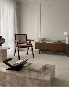 a living room filled with furniture and a book on top of a table in front of a window