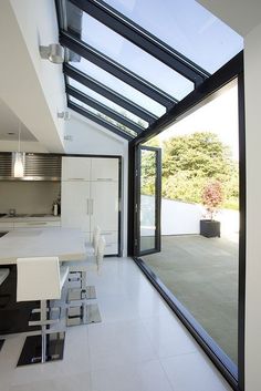 an open kitchen and dining area with glass walls