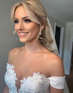 a woman in a wedding dress smiling at the camera