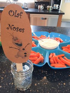 there are carrots and dip in the bowl on the kitchen counter with a sign