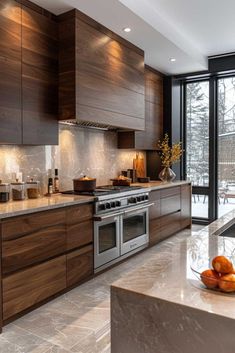 a modern kitchen with stainless steel appliances and wood cabinets, marble counter tops and flooring