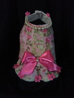 a pink flowered dog dress with pearls and bows