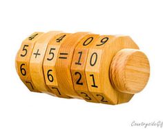 four wooden numbers are arranged in the shape of a tube with one number on each side