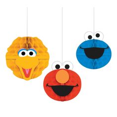 three paper balls with faces hanging from strings