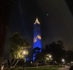 a tall clock tower lit up in the night sky with lights on it's sides