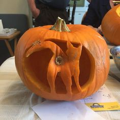 a pumpkin carved to look like an elephant is sitting on a table next to another pumpkin