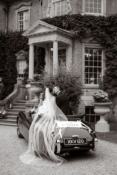 a bride and groom kissing in front of a car