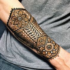 a man with a tattoo on his arm and hand is showing off the intricate design