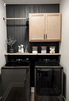 a washer and dryer in a small room with wooden cabinets on the wall