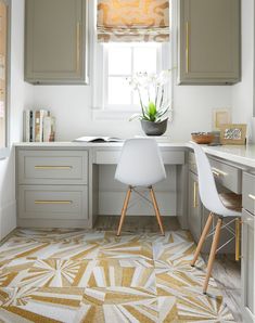 a white desk and chair in a small room with gray cabinetry, gold accents and an area rug on the floor