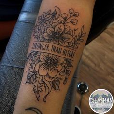 a black and white photo of a woman's arm with a quote tattooed on it