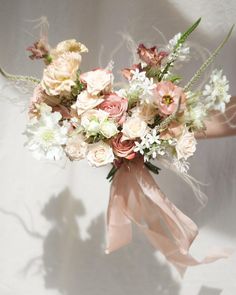 a bouquet of flowers is being held by someone's hand on a white background