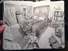 a person holding up a book with a drawing of a bedroom in the middle of it