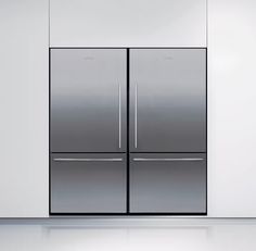 two stainless steel refrigerators sitting side by side in an empty room with white walls