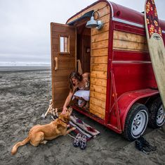 a woman and her dog are getting ready to go into the trailer on the beach