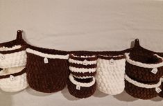 several crocheted brown and white baskets hanging from a line