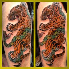 an orange and black tiger tattoo on the arm