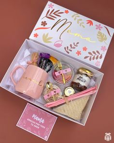 an open box with various items in it on a pink tablecloth and brown background