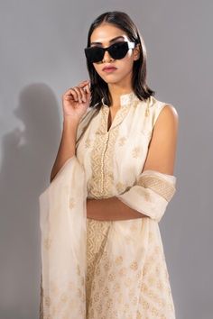 Off white short kurta with golden metallic floral hand block prints. Comes with matching printed sharara and dupatta. - Aza Fashions White Sleeveless Kurta With Zari Work, Elegant Summer Sharara With Gota Work, Sleeveless White Kurta For Diwali, Gold Sharara With Chikankari Embroidery, Summer Wedding Sharara With Gota Work, Fitted Gold Palazzo Set With Chikankari Embroidery, White Sharara With Zari Work For Summer, Gold Sets With Zari Work For Summer, Gold Sets With Dupatta For Summer