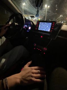 a person is sitting in a car with their hand on the steering wheel