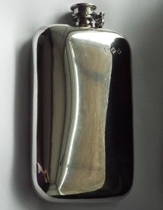 a silver flask with a black top is hanging on the wall