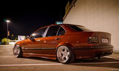 an orange car parked in a parking lot at night