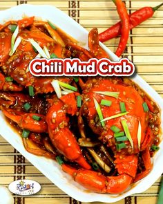 a bowl filled with cooked crabs and carrots on top of a bamboo place mat