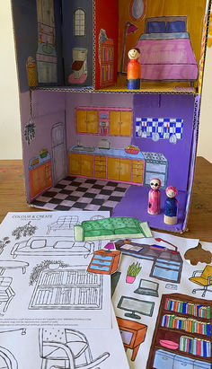 a doll house with furniture and accessories on the floor next to paper cut out drawings