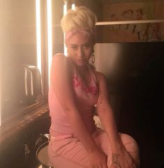 a woman sitting on top of a potty in a bathroom next to a sink