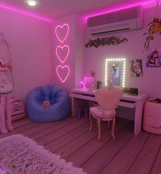 a room with pink lights and furniture in it, including a bed, desk, chair, mirror and air conditioner