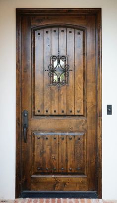 the front door is made from wood and has an iron grill on it's side