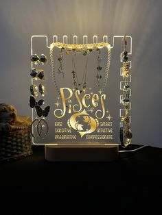 a lighted display with jewelry on it and the words piscs in gold letters