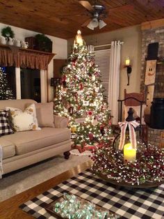 a living room decorated for christmas with a lit tree and plaid table cloth on the coffee table